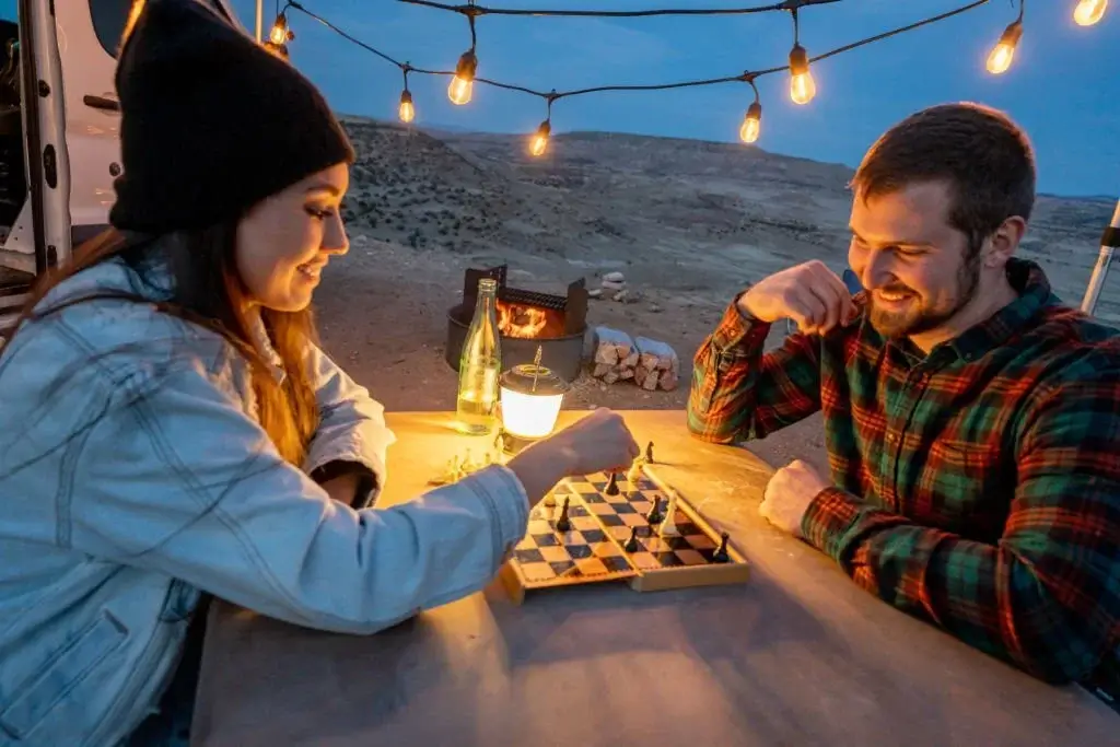 couple playing chess while out camping