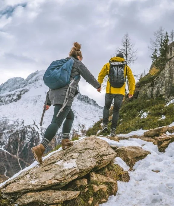 image of two people hiking along hills wearing backpacks