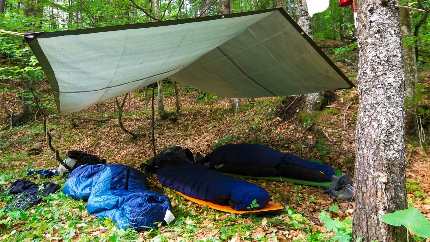 sleeping bags under a tarp, people camping