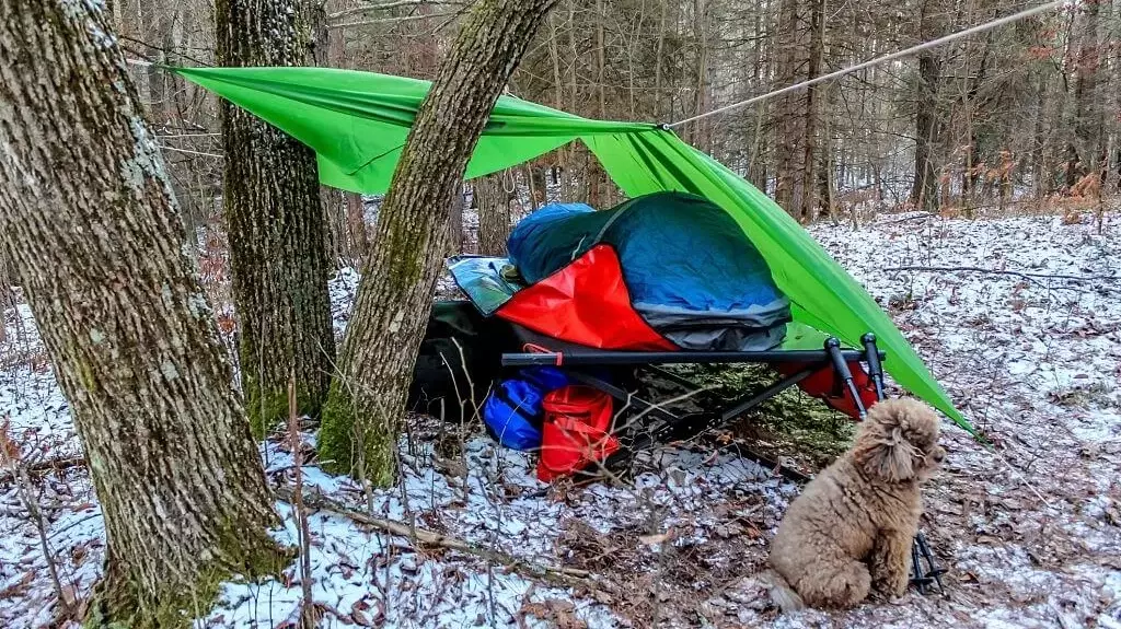 a tarp set up over camping gear