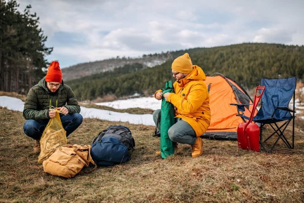 two campers getting ready to pitch a tent