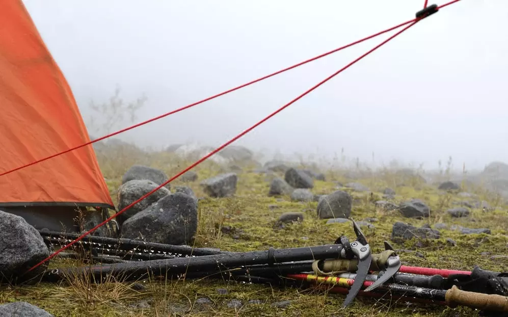 various camping and hiking gear in the rain