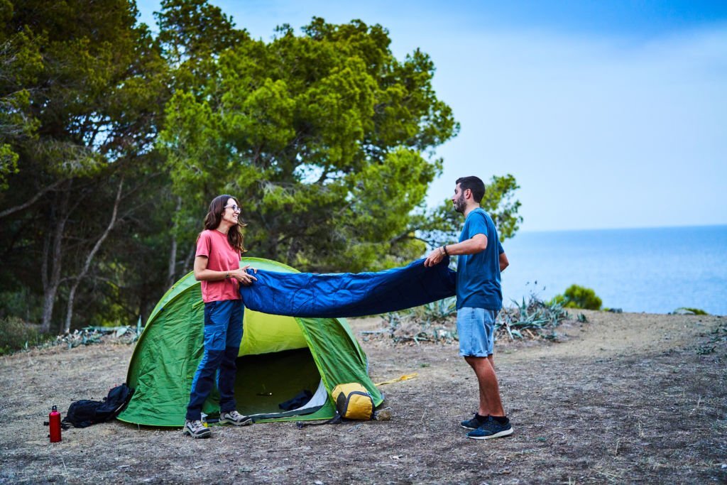 couple unfolding a sleeping bag