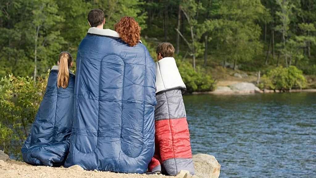 family bonding in sleeping bags while camping