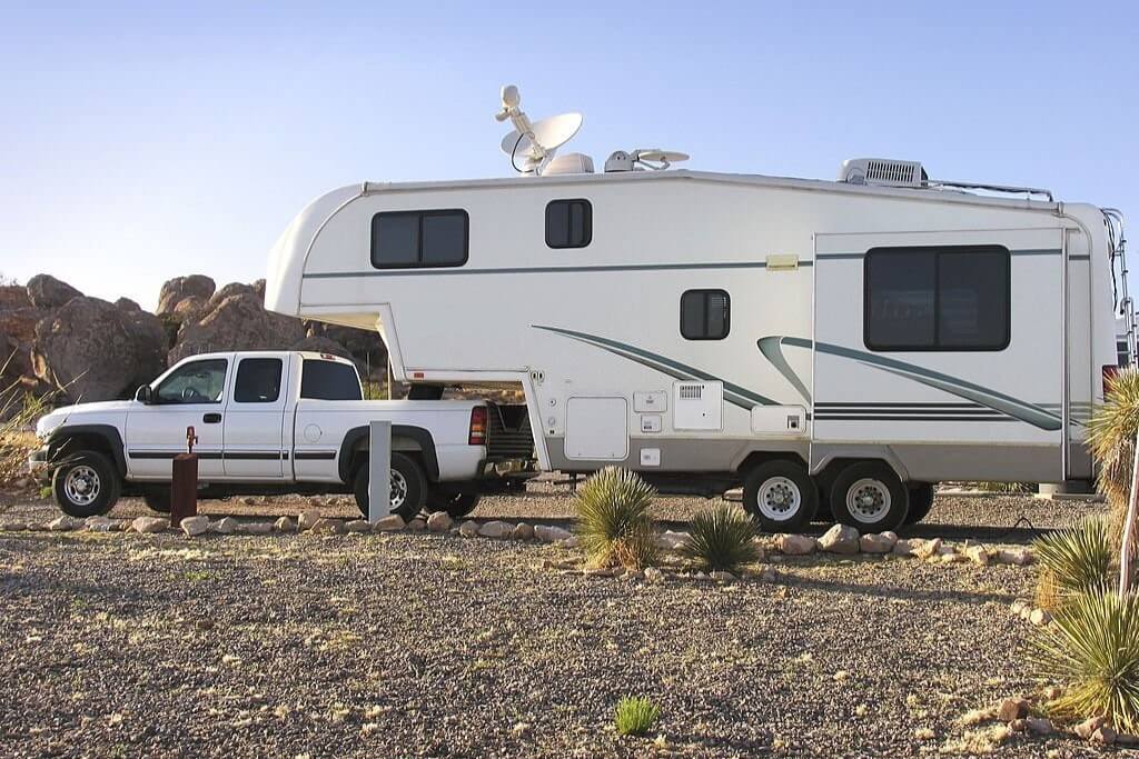 a fifth wheel trailer being towed by a pickup truck