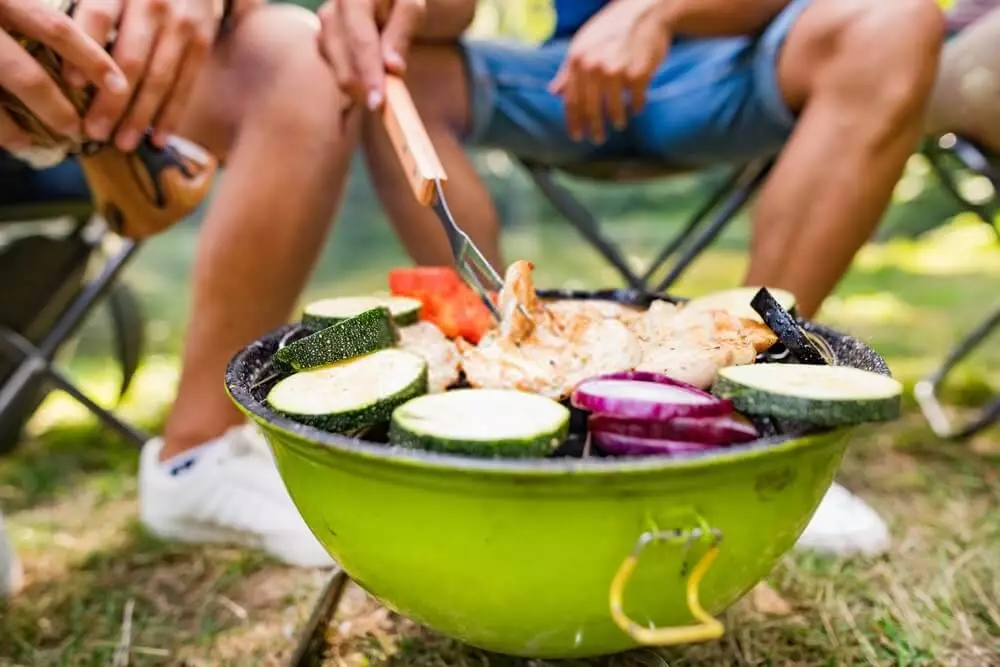 cooking vegetable and meat on a camping grill