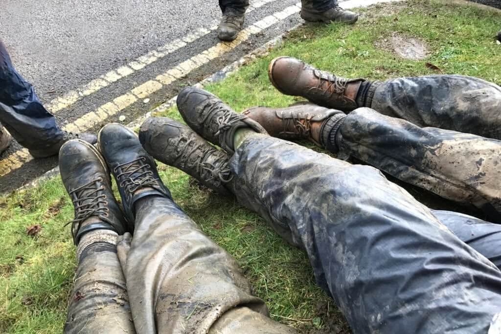 hikers with muddy waterproofed hiking shoes