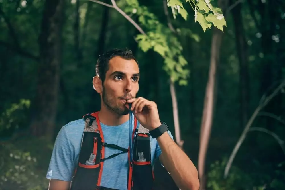 hiker drinking from hydration backpack