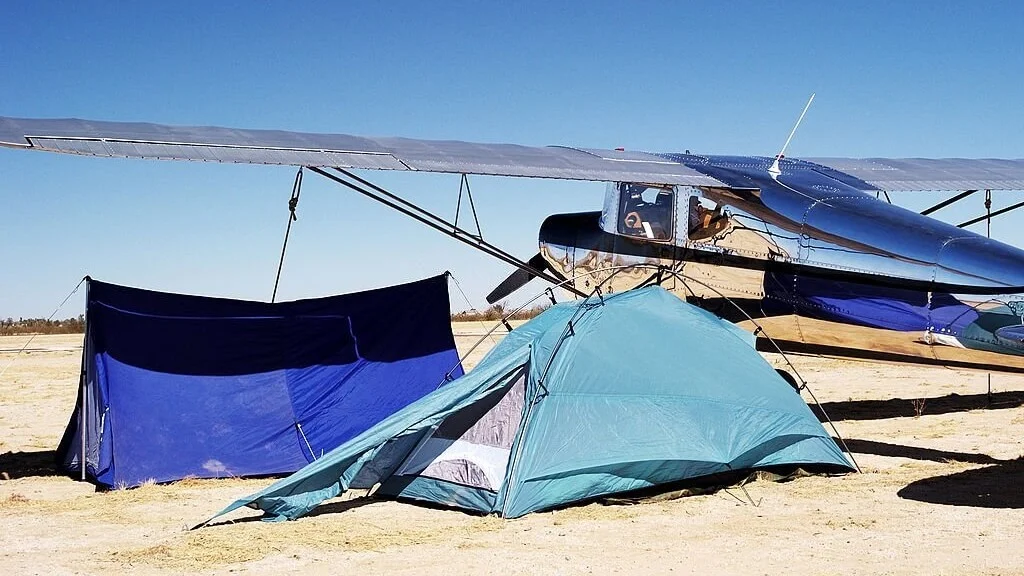 camping in tents near a plane in the wild