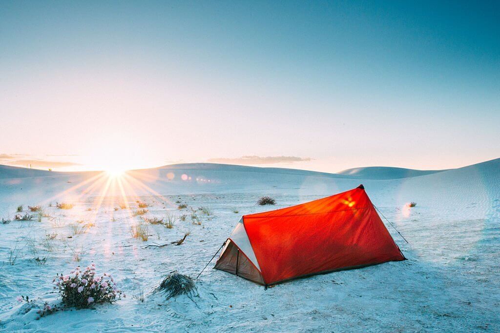 tent pitched on sand using deadman anchors