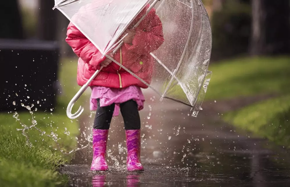 sheltering from rain using an umbrella