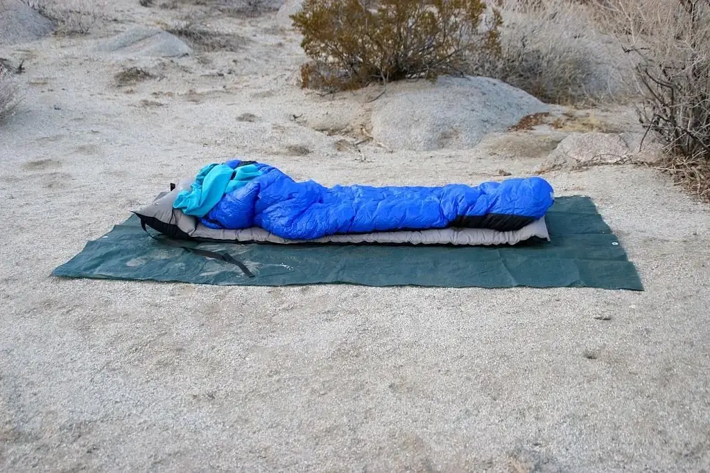 a sleeping pad and a sleeping bag on a tarp