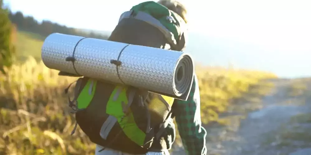 Lightweight sleeping pad tied to a backpack