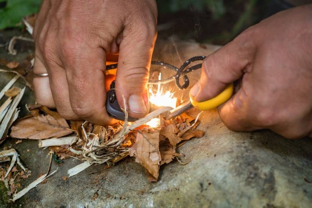 a man starting fire with flint and steel