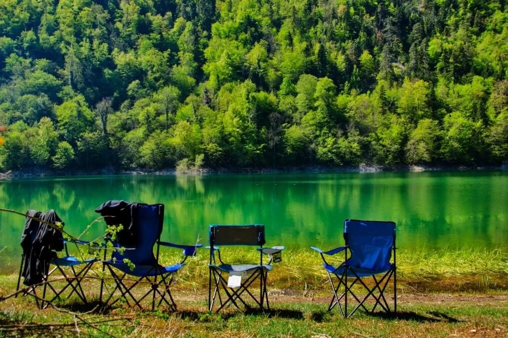 various camping chairs near a river