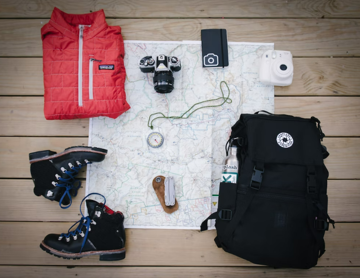 image of hiking equipment with boots, bag, map, etc